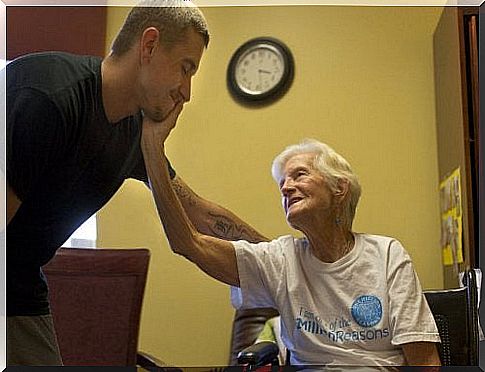 The old woman touches the man's face