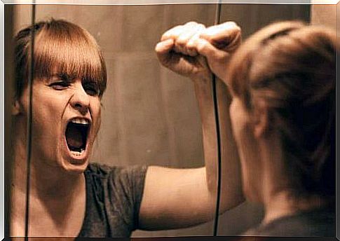 Emotional suffering - a woman screams in front of a mirror