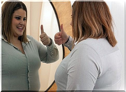 Smiling woman in the reflection of the mirror - happiness