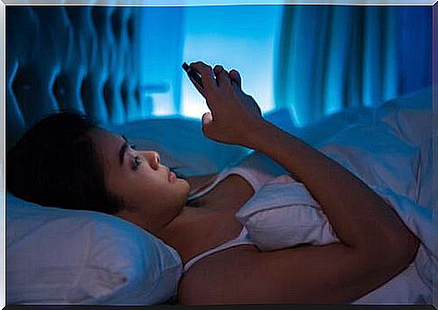 woman in bed in front of the phone