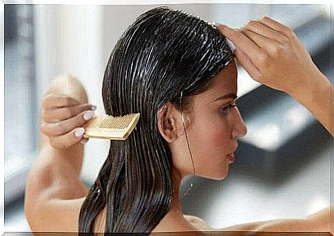 The woman is brushing her wet hair