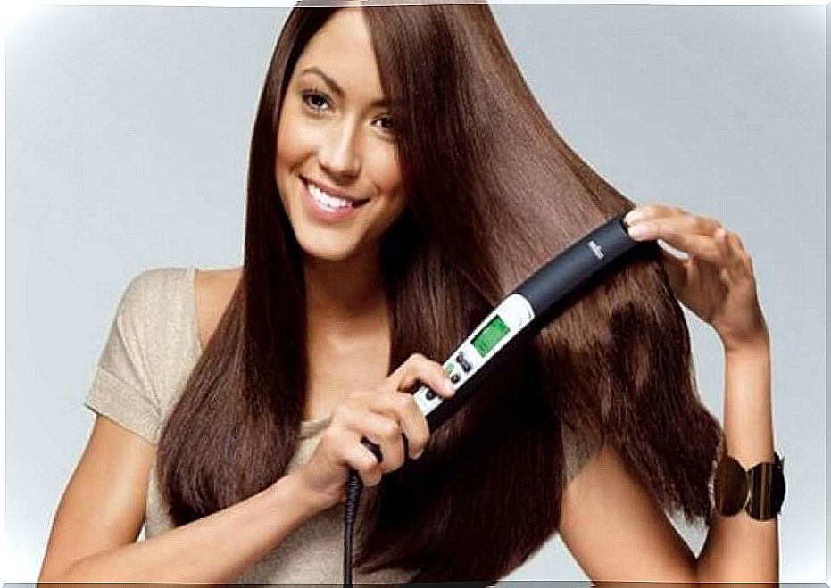 The woman straightens her hair